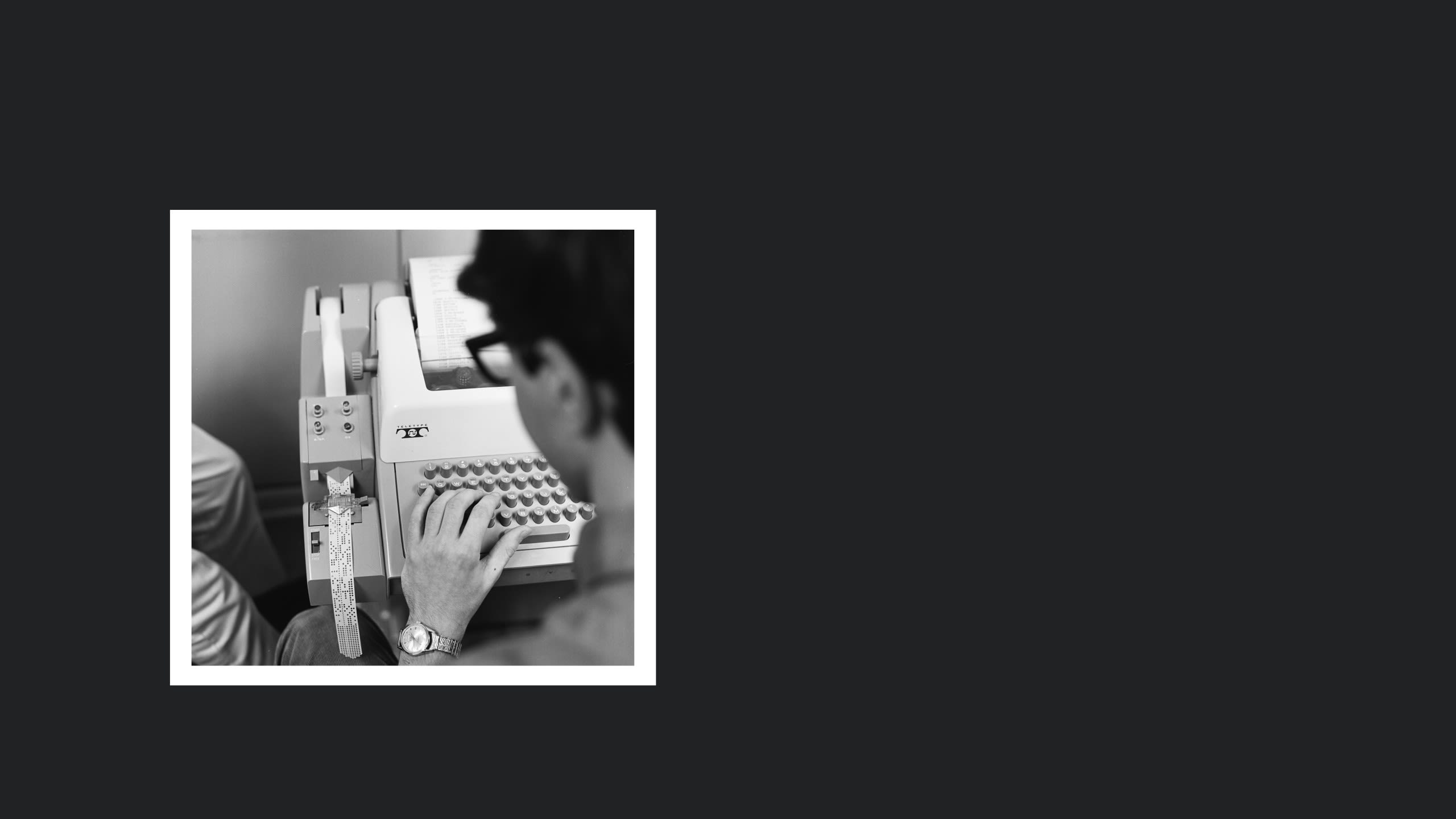 A teenager types on a teletype machine.