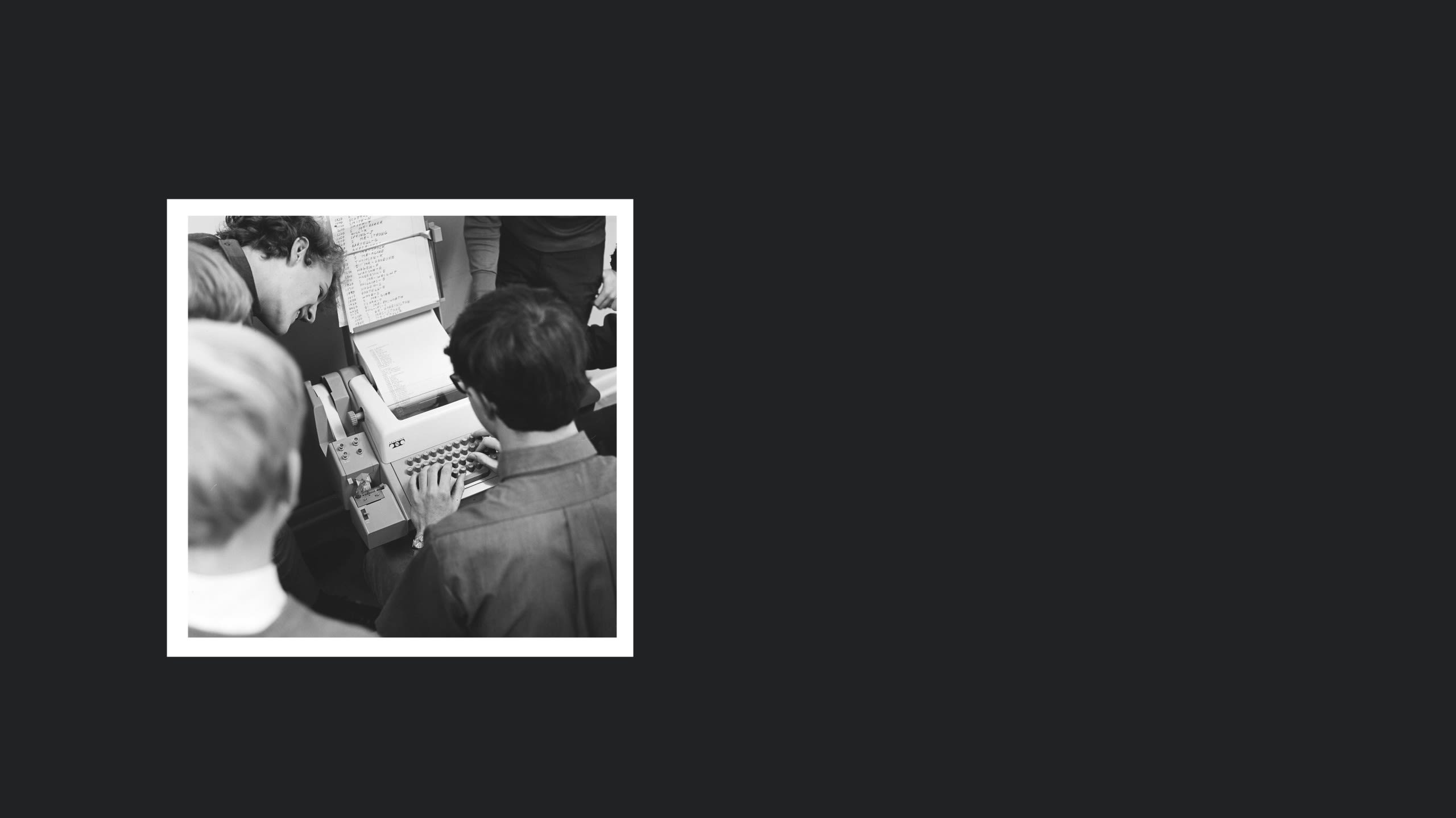 Three teenagers gathered around a teletype machine.