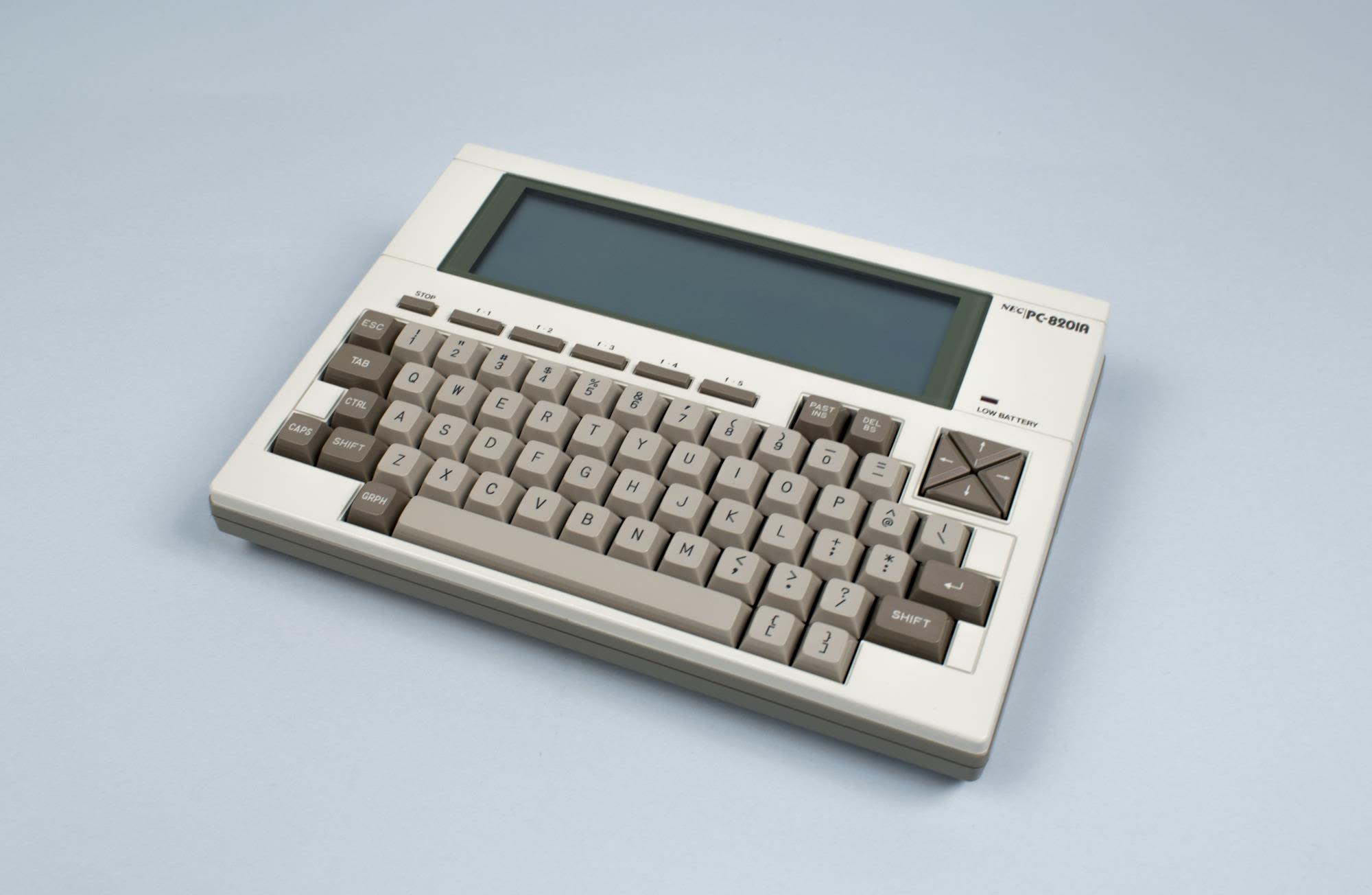 An early home computer. It is one piece with a keyboard and a small LCD screen.